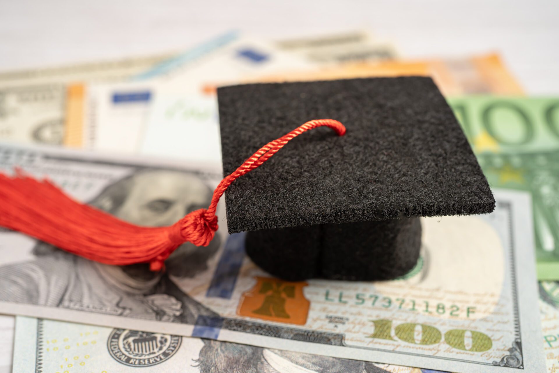 Graduation gap hat on Euro and US dollar banknotes money