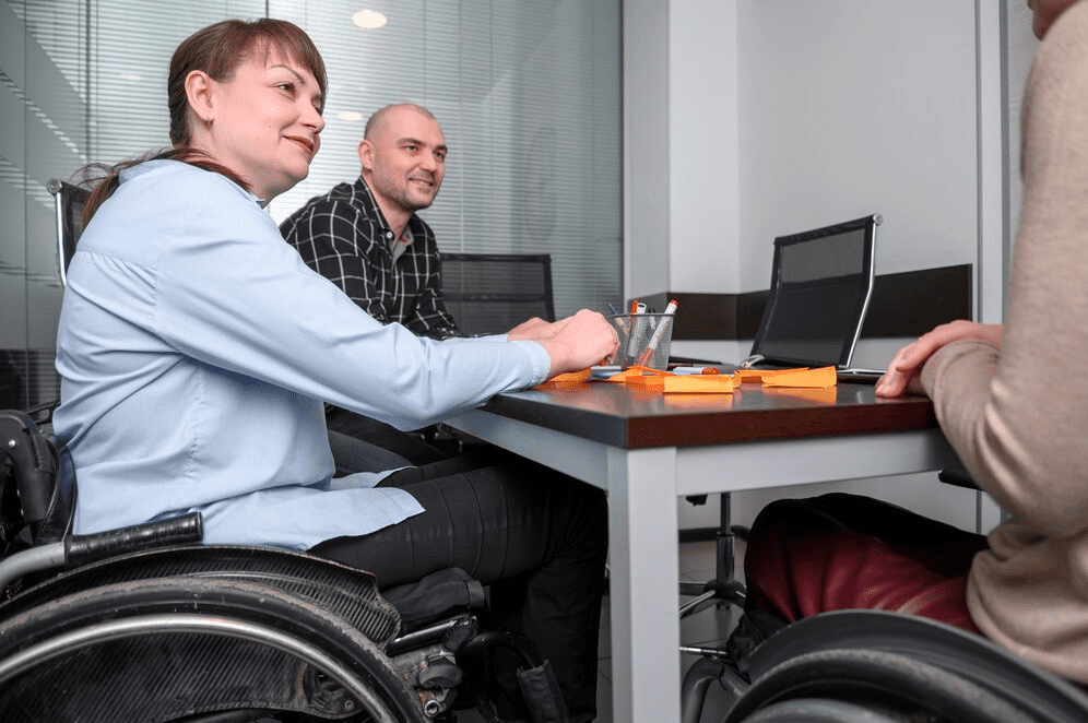 Confident businesswoman in wheelchair at the desk